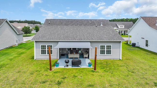 Rear view of property featuring central AC unit, a yard, and a patio | Image 40