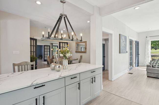 Kitchen featuring open floor plan, light stone counters, recessed lighting, hanging light fixtures, and light wood-type flooring | Image 17