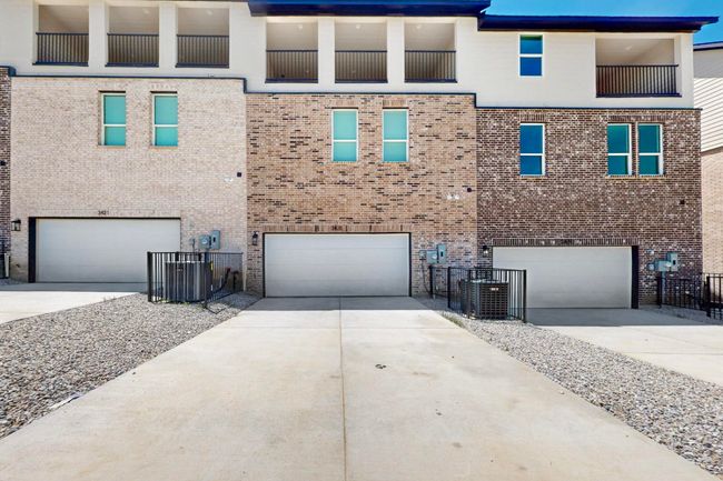 View of front of house featuring an attached garage, concrete driveway, and brick siding | Image 38