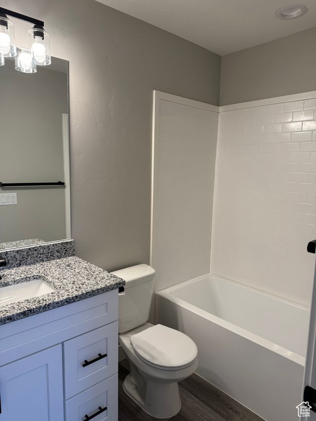 Full bathroom featuring shower / bathtub combination, wood-type flooring, toilet, and vanity | Image 7