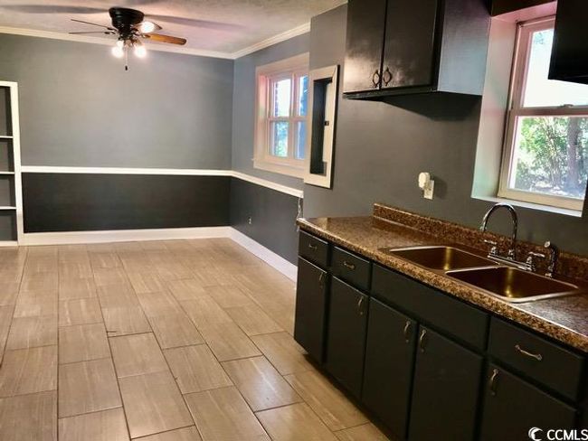 Kitchen with ornamental molding, plenty of natural light, ceiling fan, dark countertops, and dark cabinetry | Image 4