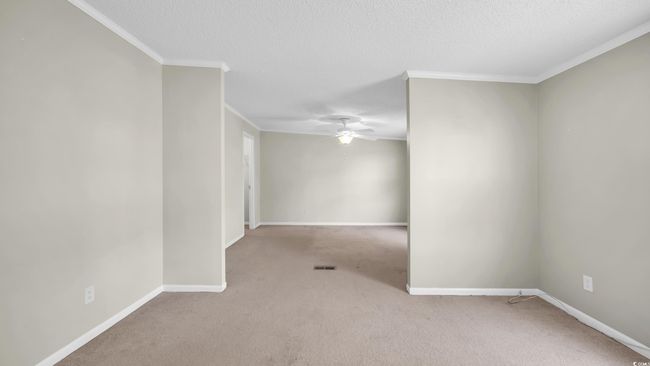 Empty room featuring ceiling fan, carpet flooring, crown molding, and a textured ceiling | Image 15