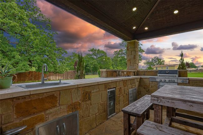 View of patio featuring a sink, fence, area for grilling, and wine cooler | Image 22