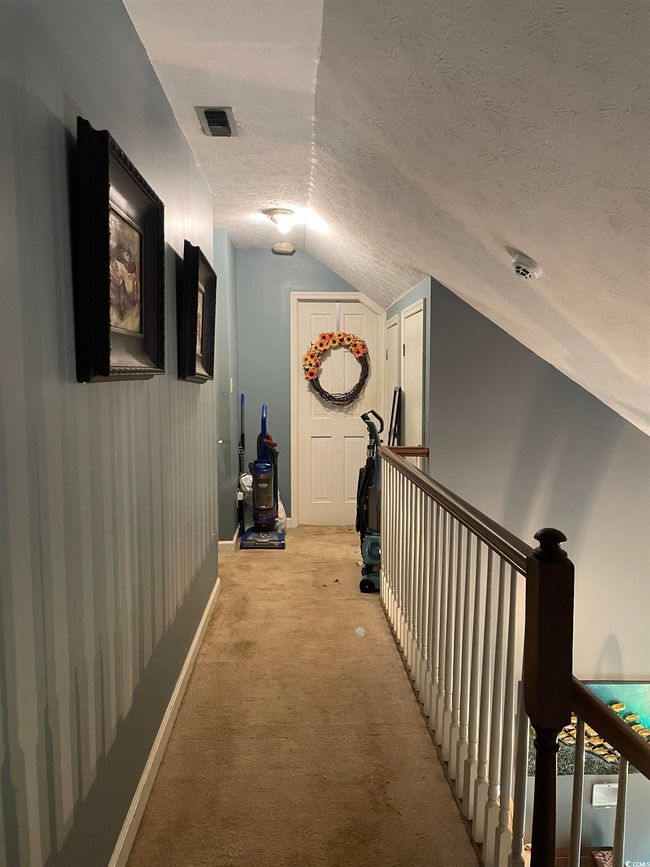 Corridor featuring lofted ceiling, a textured ceiling, light carpet, and an upstairs landing | Image 25