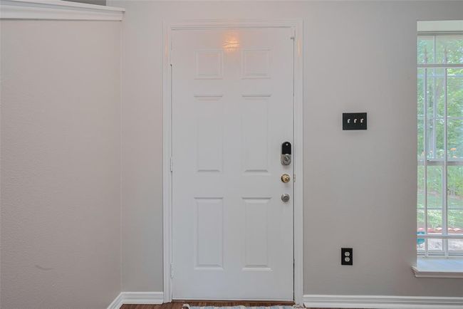 Step from the living room through the inviting front door onto your welcoming porch. | Image 6
