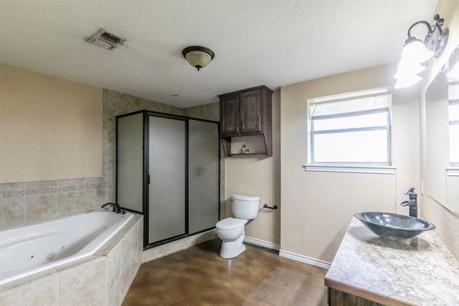Full bathroom with concrete flooring, a textured ceiling, visible vents, a jetted tub, and a shower stall | Image 18