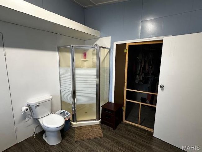 Bathroom with a shower with door, toilet, and wood-type flooring | Image 4
