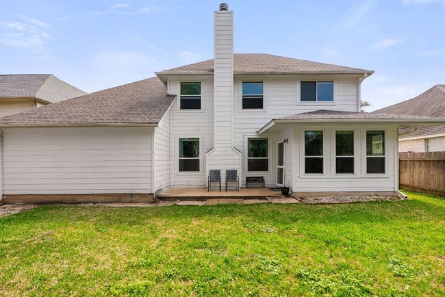 Back of property featuring a patio area, a yard, fence, and a chimney | Image 25