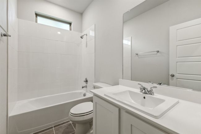 Full bath with toilet, bathing tub / shower combination, vanity, and tile patterned floors | Image 17