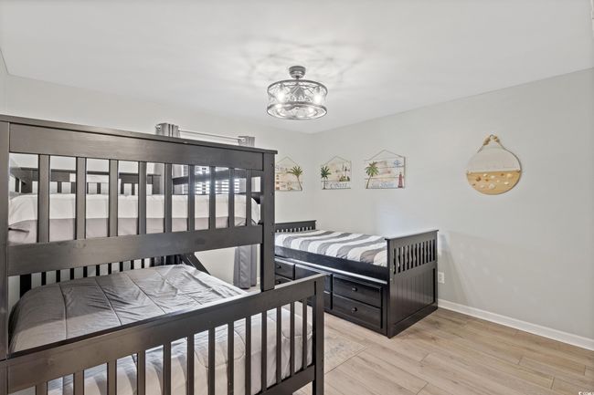 Bedroom featuring baseboards, light wood-style flooring, and a chandelier | Image 18