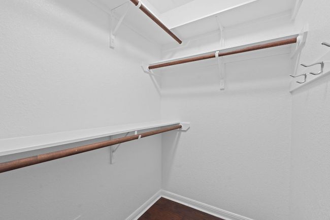 Walk in closet with dark wood-style flooring | Image 30