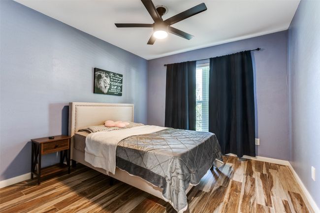 Bedroom with wood finished floors and ceiling fan | Image 17