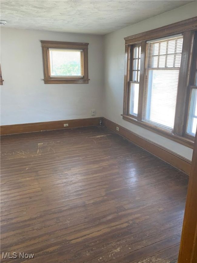 Spare room with baseboards and dark wood-style floors | Image 6