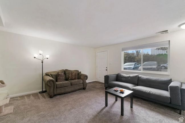 Carpeted living room featuring visible vents and baseboards | Image 5