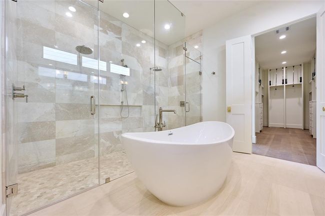 Luxurious primary bath featuring an elegant oval-shaped soaking tub. | Image 29