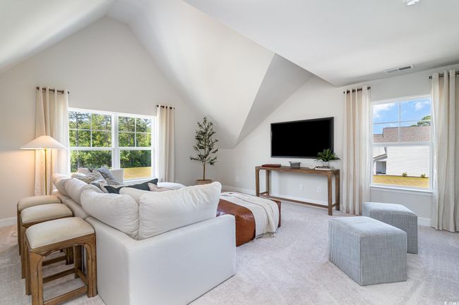 Living area with lofted ceiling, visible vents, baseboards, and light carpet | Image 24