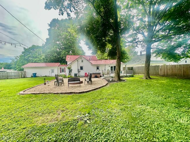 rear view of house with a patio, a fenced backyard, and a metal roof | Image 12