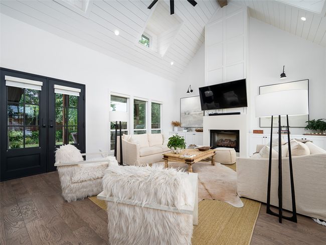 Living room with high vaulted ceiling, dark wood-style flooring, healthy amount of natural light, a fireplace, and a wood ceiling with exposed beams | Image 6
