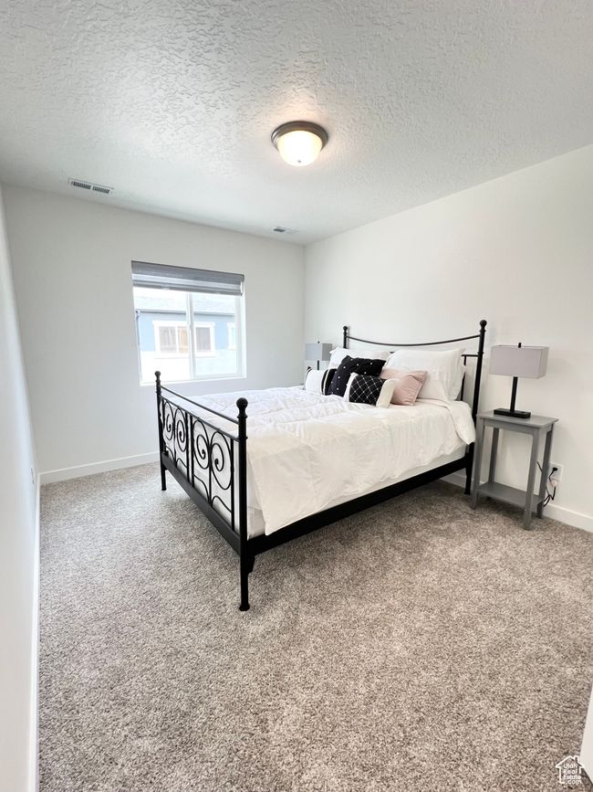 Carpeted bedroom featuring a large window and walk-in closet | Image 15