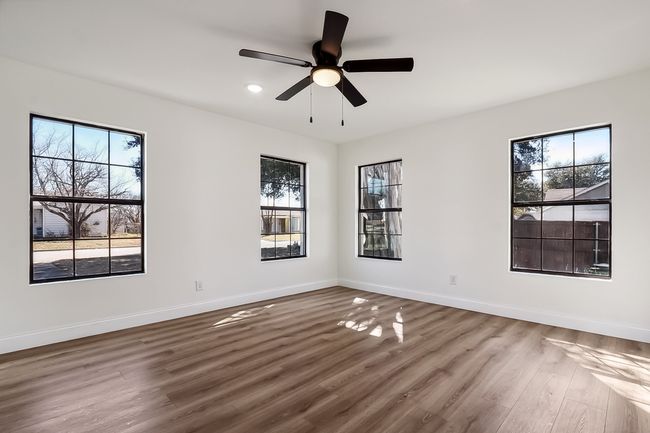 Unfurnished room featuring ceiling fan, baseboards, and wood finished floors | Image 19
