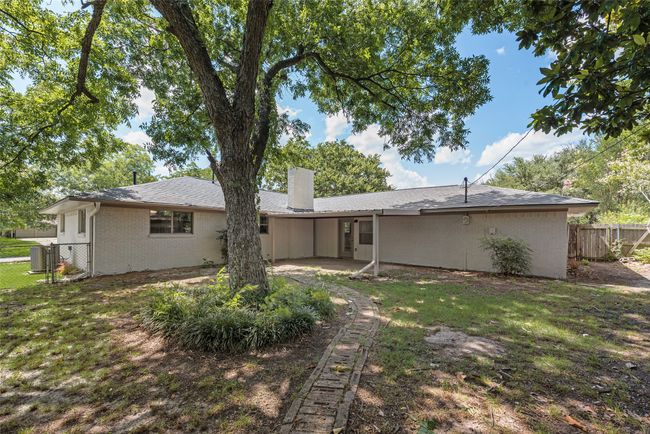 Back of house featuring a chimney, brick siding, and a covered back patio | Image 27