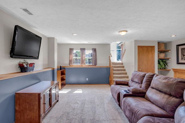 Living room featuring light carpet, stairs, and a textured ceiling | Image 25