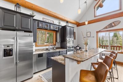 Kitchen with plenty of natural light, stainless steel appliances, granite countertops. | Image 2