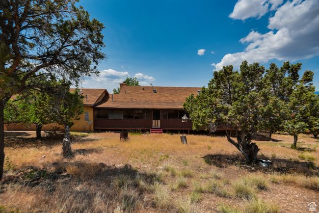 Rear view of property featuring a wooden deck and a shingled roof | Image 6