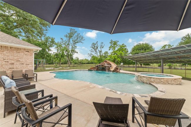 Tucked away on 1.5 serene acres in Manvel, this distinctive property is built for the way you want to live. The flexible floorpan allows between 4 to 6 bedrooms, 2.5 baths, a 2-car garage, in-ground pool, plus a 60'x30' insulated shop. | Image 40