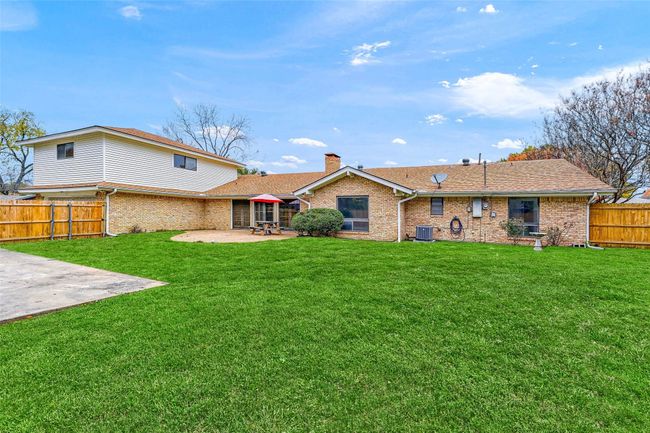 Rear view of property with a patio, a chimney, brick siding, and a fenced backyard | Image 37