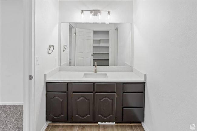 Bathroom featuring vanity, baseboards, visible vents, and wood finished floors | Image 19