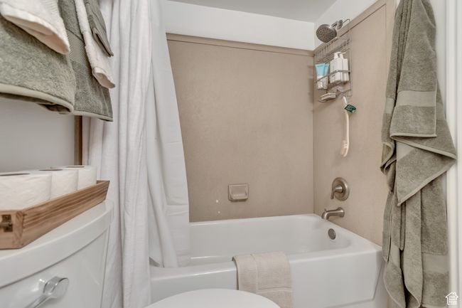Bathroom featuring shower / bath combination with curtain and toilet | Image 11