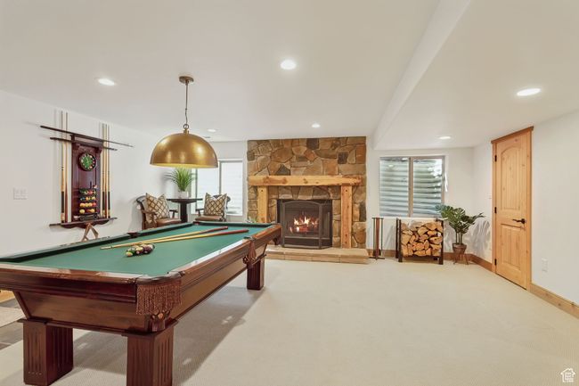 Recreation room with carpet floors, recessed lighting, billiards, a fireplace, and baseboards | Image 48