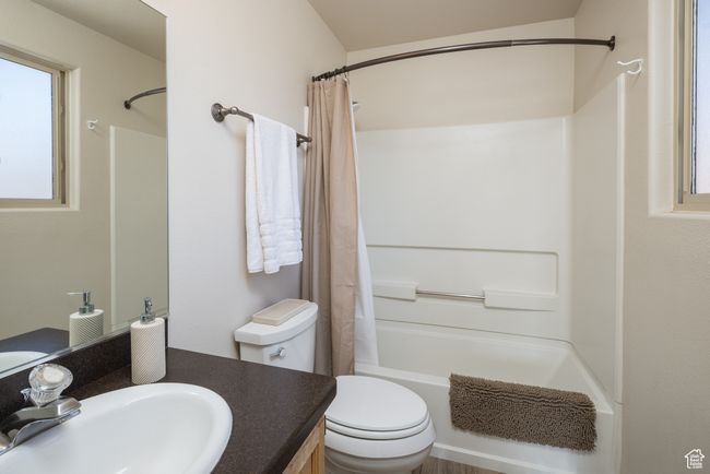 Full bathroom with vanity, toilet, and shower / bath combo with shower curtain | Image 29