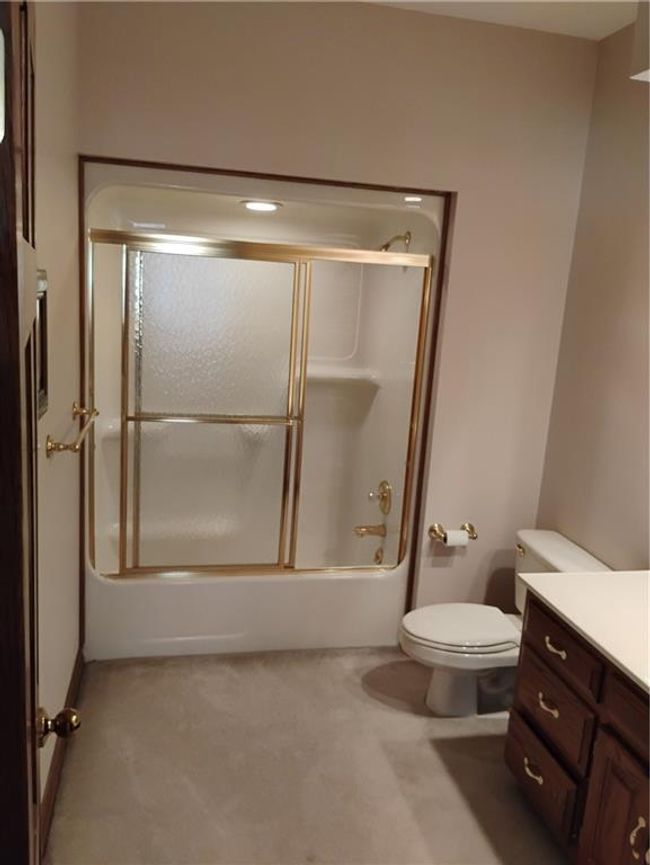 Upstairs Full bath featuring bath / shower combo with glass door, toilet, and vanity | Image 69