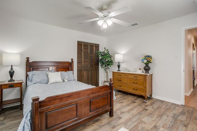 Bedroom featuring a closet, light wood-style flooring, and a ceiling fan | Image 30