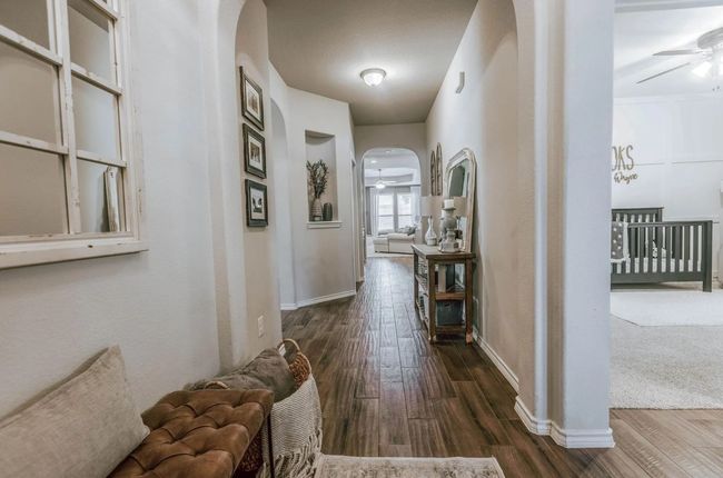 Corridor featuring arched walkways, dark wood finished floors, and baseboards | Image 8