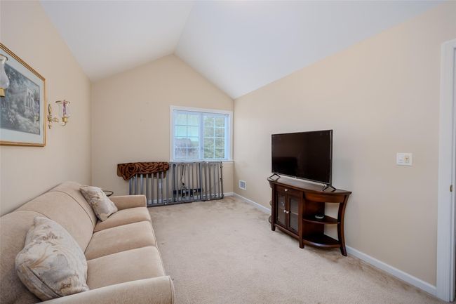 Carpeted living room featuring lofted ceiling and baseboards | Image 20