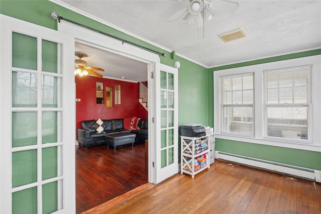 Sunroom with a baseboard radiator, visible vents, and plenty of natural light | Image 14