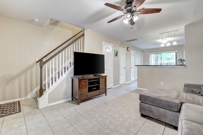 Living room featuring stairway, light tile patterned floors, ceiling fan, and baseboards | Image 6