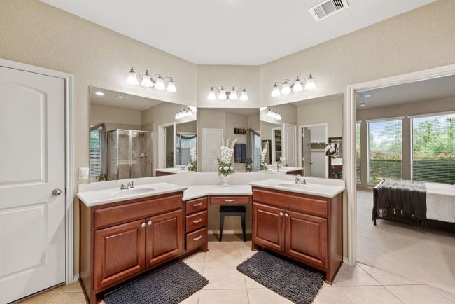 Full bathroom with double vanity, a shower stall, tile patterned floors, and connected bathroom | Image 16