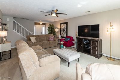 Carpeted living room featuring a textured ceiling and ceiling fan | Image 3