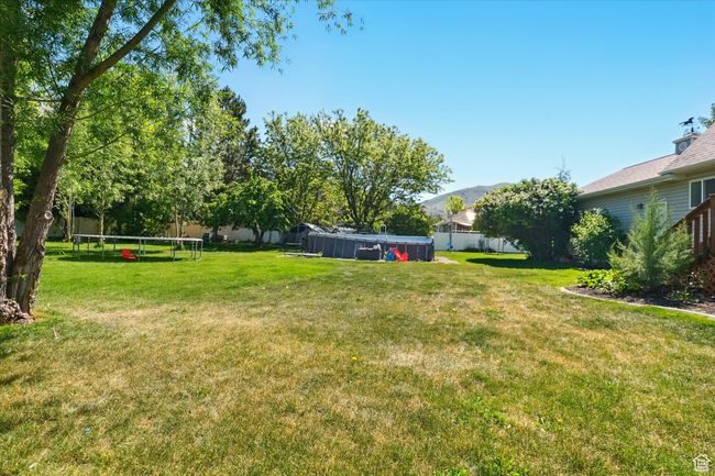 View of yard featuring a trampoline and a mountain view | Image 32
