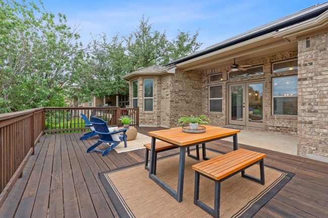 Covered patio featuring French doors, a ceiling fan, and an expansive deck | Image 31