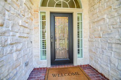 Beautiful stone all across the front of the home with a lead glass door. | Image 3