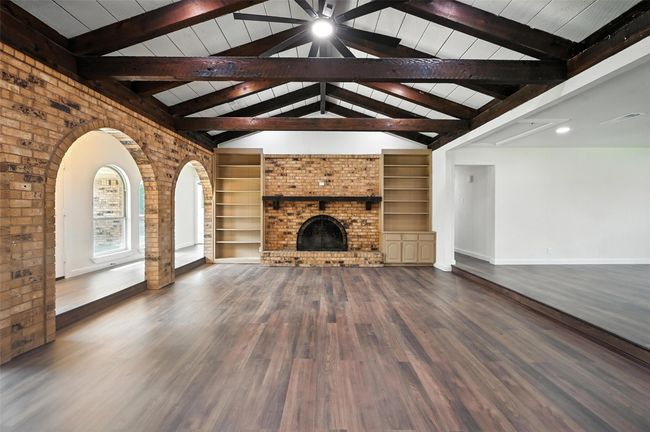 So much character in the living room, from the built in shelfs, to the arch ways and the wooden beams above. | Image 4