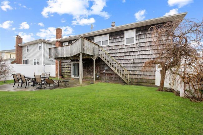 Rear view of property featuring a lawn, a deck, a patio area, stairway, and fence | Image 27