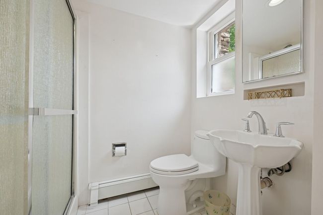 Full bath with a baseboard heating unit, tile patterned flooring, a shower stall, and toilet | Image 18