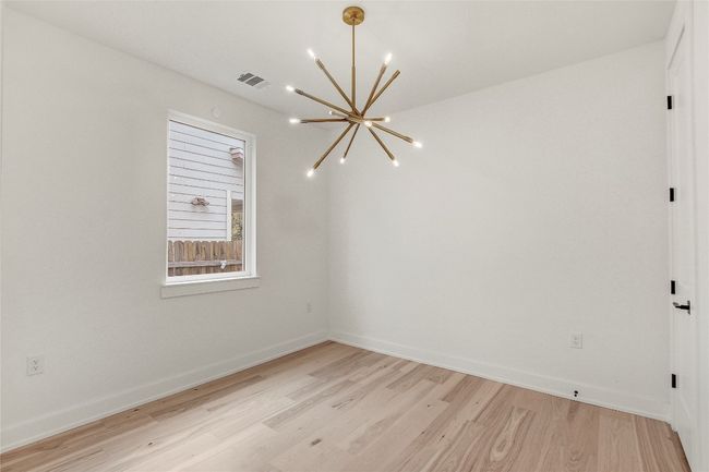 Unfurnished room featuring a chandelier, light wood-style flooring, and baseboards | Image 12