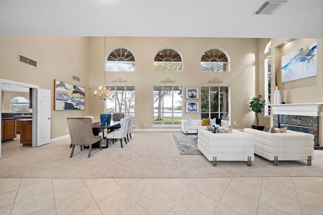 Bathed in natural light, this elegant living space is designed with the discerning waterfront buyer in mind, features soaring ceilings and large arched windows that frame the stunning lake views. | Image 9